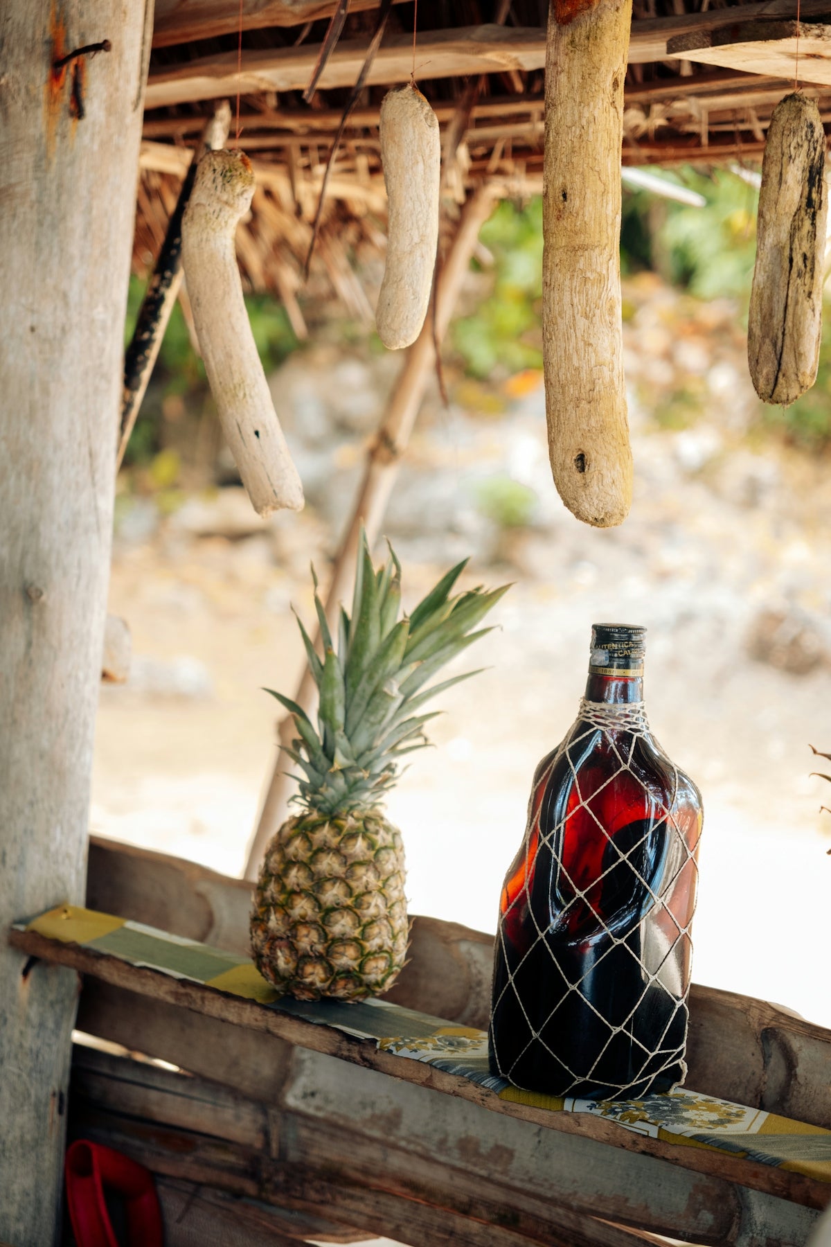 Pineapple and rum bottle on wooden shelf