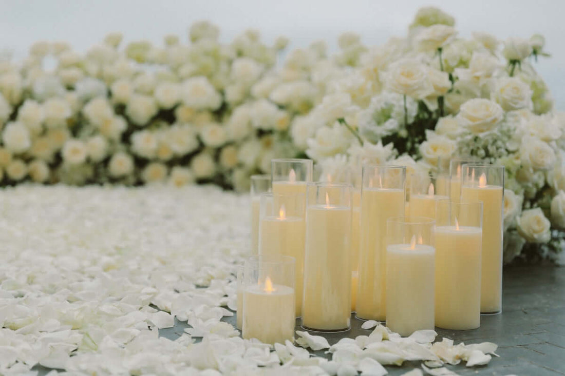cedarwood luxury candle Katy TX Lit candles surrounded by white rose petals and flowers