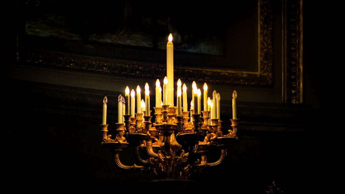 apple cinnamon crunch candle Elegant chandelier with candles glowing in a dark room, perfect for setting a luxurious ambiance.