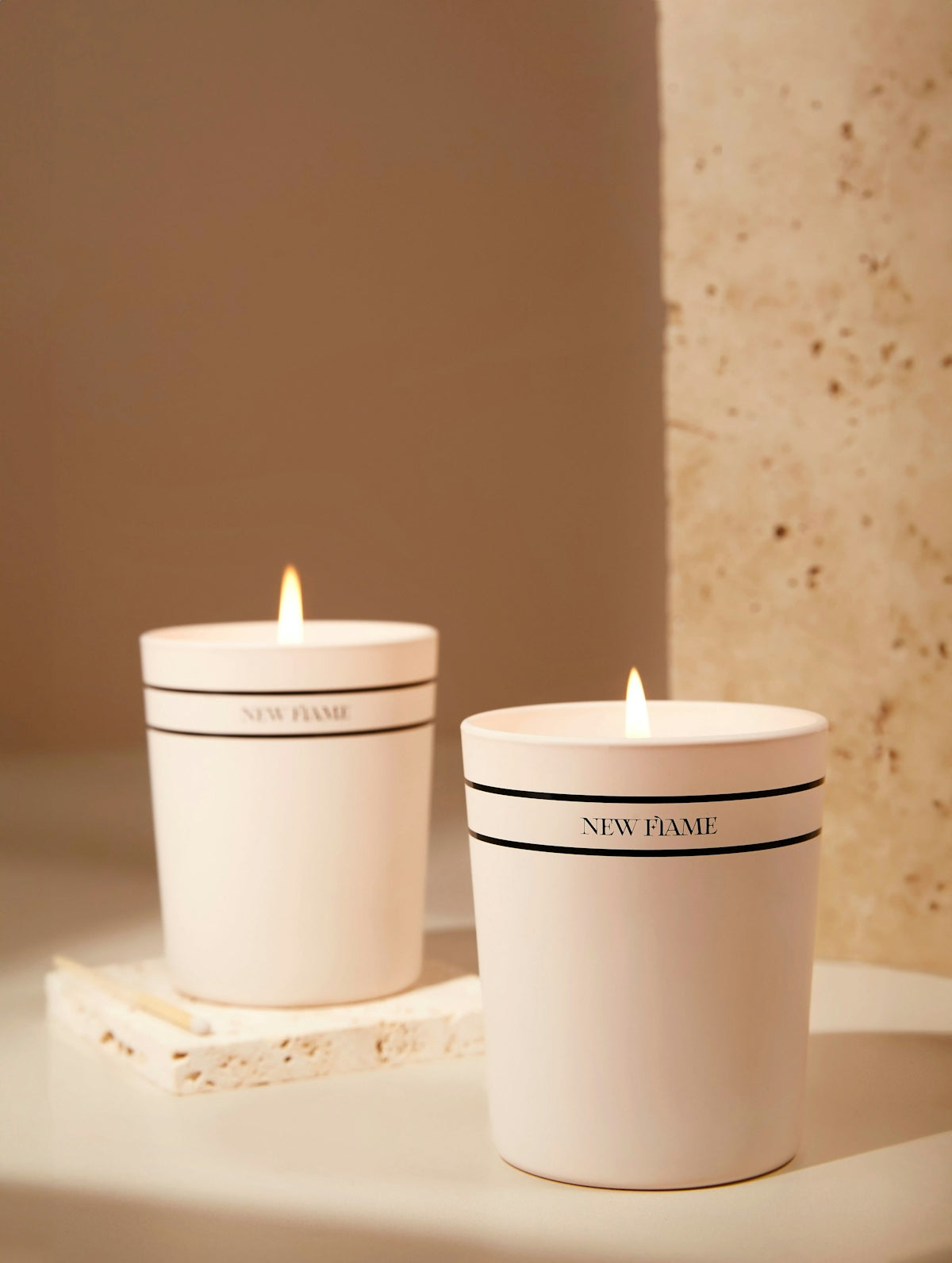 a couple of white candles sitting on top of a table
