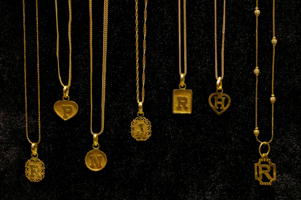 Several gold necklaces with initial pendants displayed