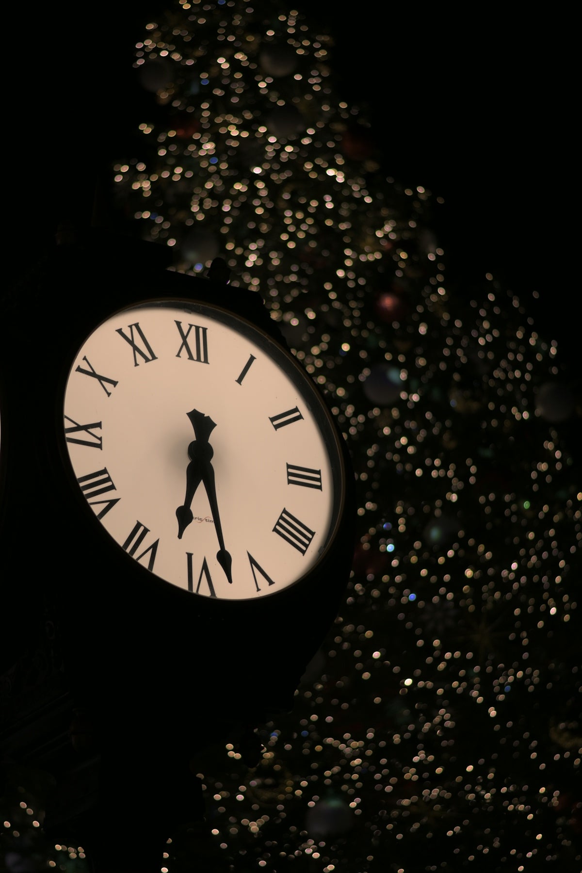 A clock face with roman numerals at night.