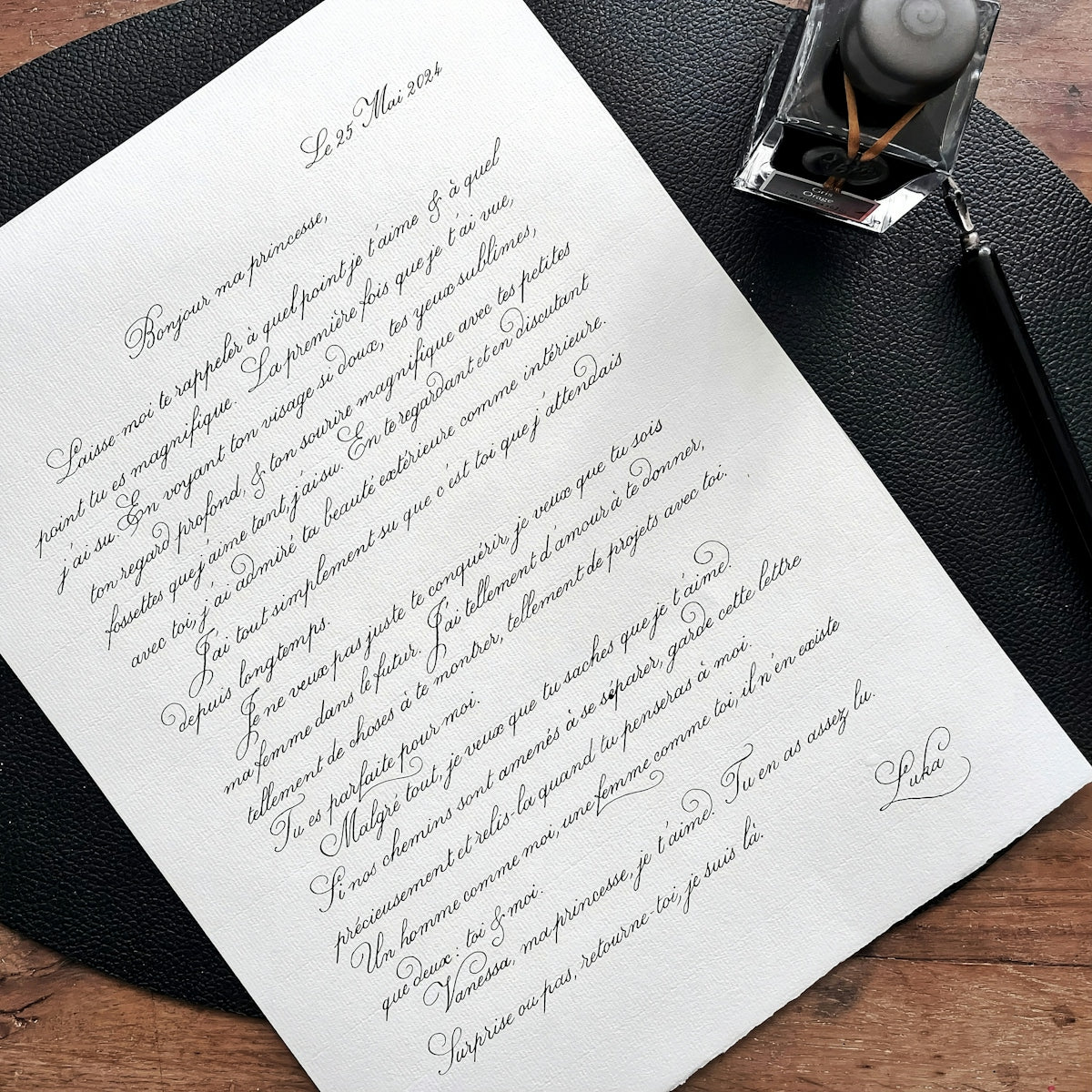 A handwritten letter with calligraphy and inkwell and quill