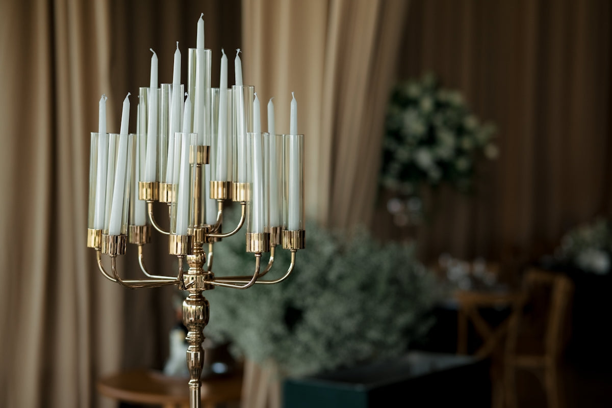 A brass candelabra holding many white candles