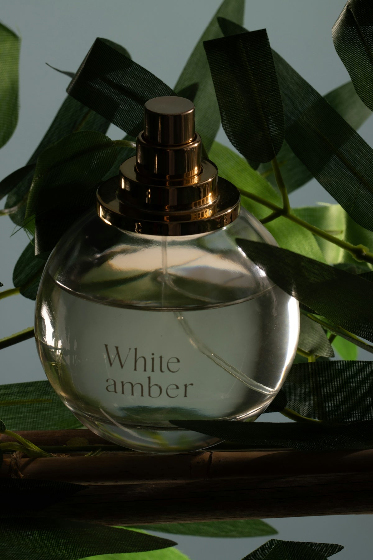 Clear perfume bottle 'white amber' with green leaves