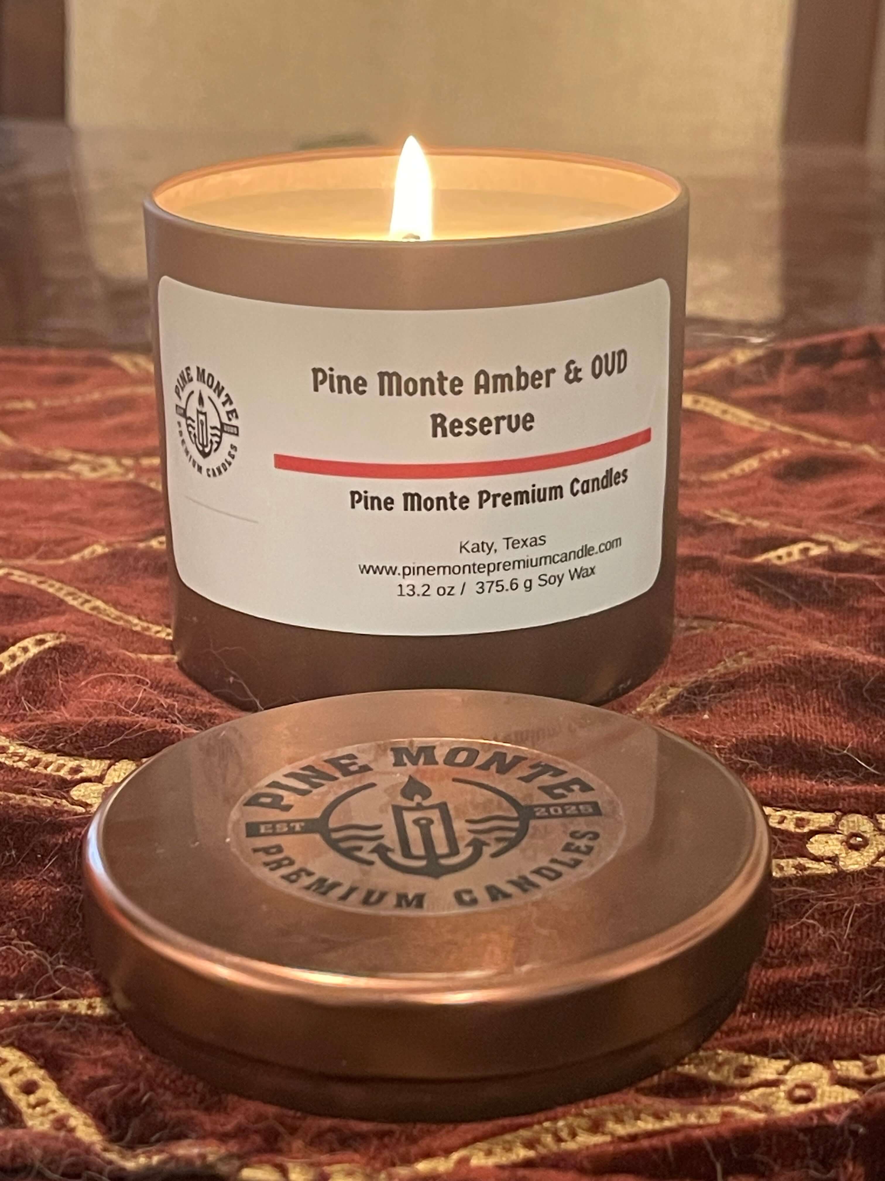 Amber & Oud Reserve Soy Candle in candle holder with lid, glowing flame, Pine Monte Premium Candles