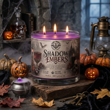 Shadow Embers Soy Candle in a cozy Halloween setting with pumpkins and a cauldron.