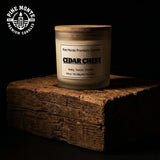 Cedar Chest 3 Wick Soy Candle on a wooden block with a natural rustic backdrop, featuring premium cedarwood scent.