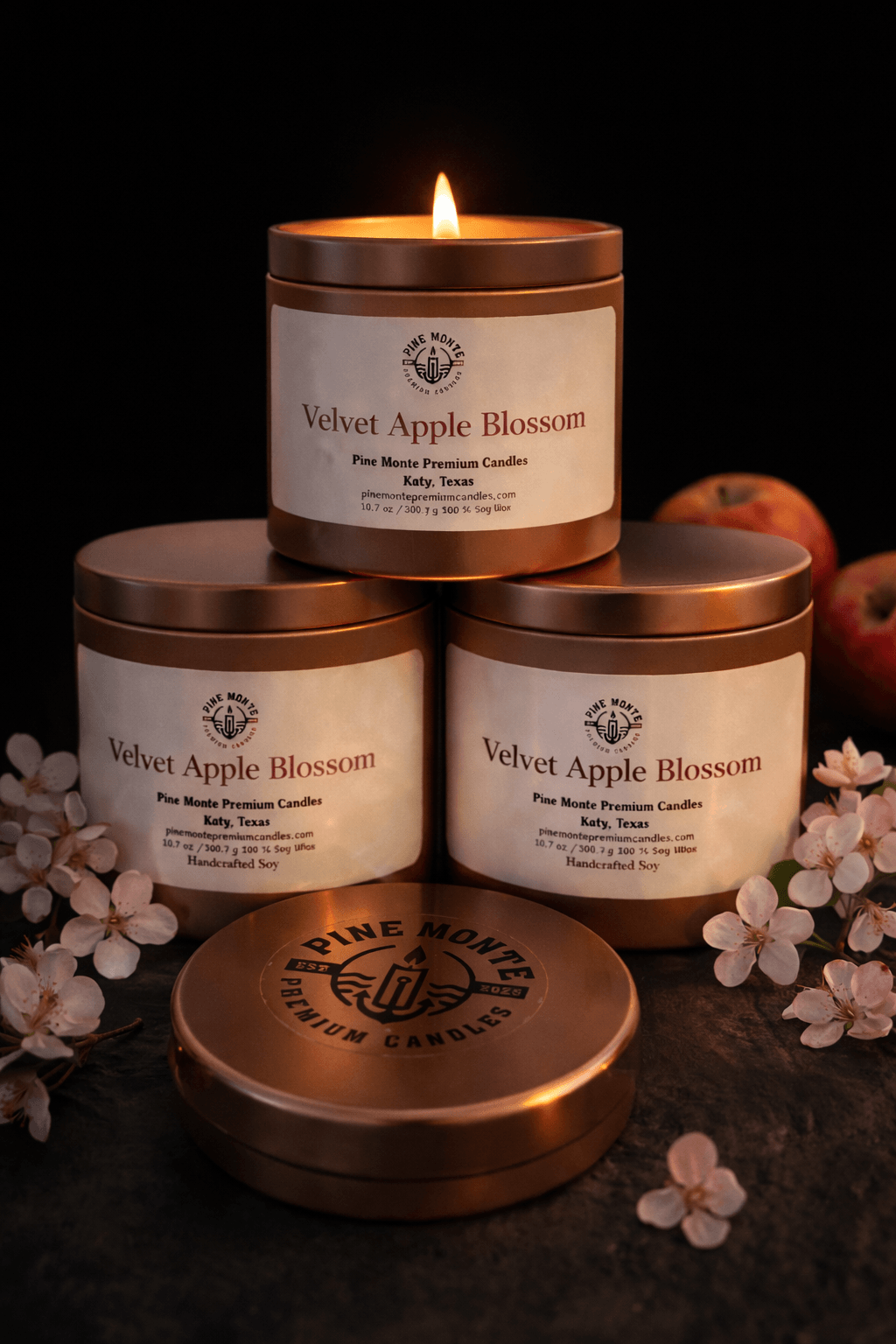 Velvet Apple Blossom Soy Candle products stacked with a warm glow, surrounded by apples and flowers.