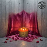 Midnight Blush Soy Candle displayed with rose petals on a luxurious pink velvet backdrop.